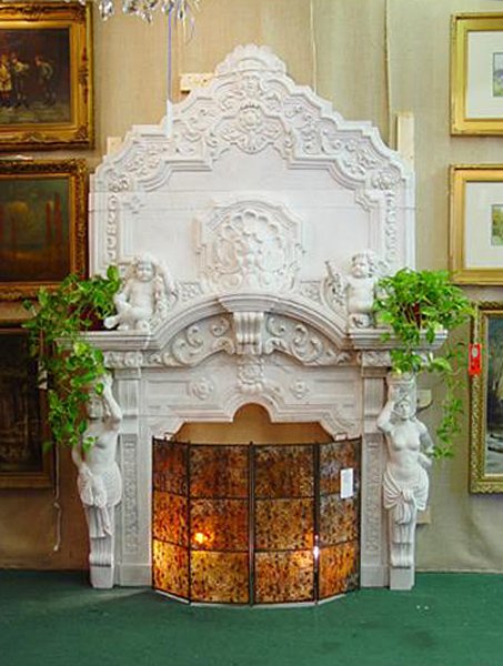 LARGE ELABORATELY CARVED WHITE MARBLE MANTLE: Large elaborately carved white marble mantle with full standing figure and cherubs carved over the top. Mantle is comprised of nine components and is currently crated for ease of transport. Kamelot Au