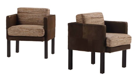 PAIR OF COWHIDE ARM CHAIRS HAVING FABRIC COVERED CUSHIONS AND RESTING ON EBONIZED LEGS.