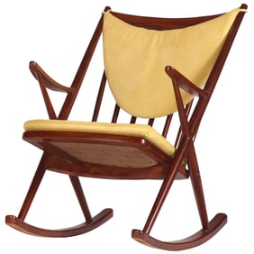 A MAHOGANY SPINDLE BACK ROCKING CHAIR WITH LOOSE CUSHION UPHOLSTERY.