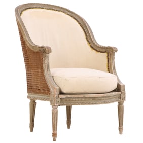 PAINTED FRENCH LOUIS XVI STYLE BERGERE CHAIR HAVING A CANE BACK AND LOOSE CUSHION SEAT C 1880.