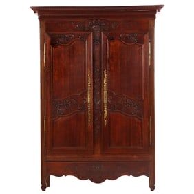 FRENCH NINETEENTH CENTURY CARVED OAK ARMOIRE HAVING BASKETS OF FLOWERS AND ELONGATED BRASS