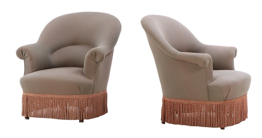 PAIR OF NAPOLEON III STYLE UPHOLSTERED LOUNGE CHAIRS C 1900 HAVING CURVED BACKS AND FRINGE
