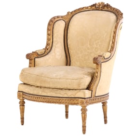 FRENCH GILTWOOD BERGERE CHAIR IN THE LOUIS XVI STYLE C 1910. HAVING A WONDERFULLY CARVED FRAME