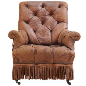 NINETEENTH CENTURY LEATHER UPHOLSTERED LIBRARY CHAIR RESTING ON EBONIZED TURNED FEET AND HAVING