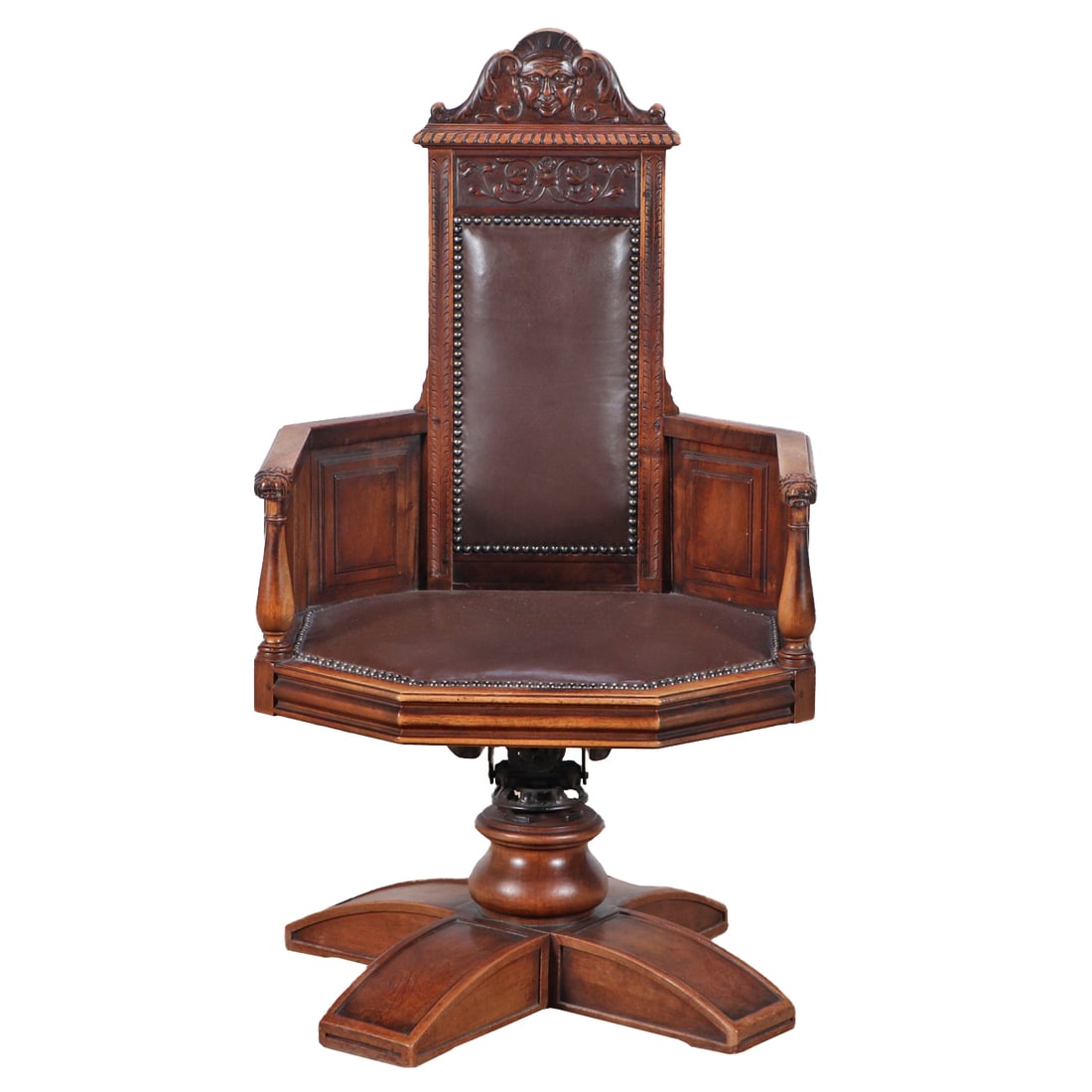 A LATE 19TH CENTURY FRENCH CARVED WALNUT EXECUTIVE CHAIR HAVING A FIGURAL BACK RAIL AND BRASS STUD: A late 19th century French carved walnut executive chair having a figural back rail and brass stud decorated leather upholstery. Ht: 41.5" Wd: 23.25" Dpth: 21" Seat: 16.5"