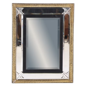 A VENETIAN STYLE BEVELED MIRROR HAVING EBONZIED BORDER SURROUNDED BY AN INTRICATE BRASS BORDER