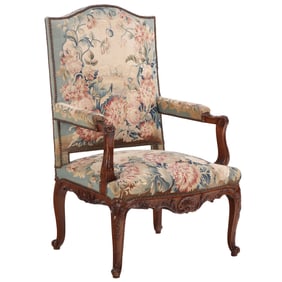 A FRENCH LOUIS XV STYLE CARVED WALNUT OPEN ARMCHAIR HAVING FLORAL NEEDLEPOINT UPHOLSTERY