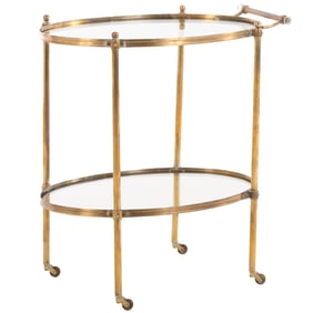 AN OVAL BRASS AND GLASS BAR CART HAVING BALL FORM FINIALS AND RESTING ON WHEELS CIRCA 1970.