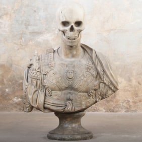 CARVED STONE BUST ON A MARBLE PLINTH DEPICTING A ROMAN SOLDIER WITH A SKULL AS A HEAD.