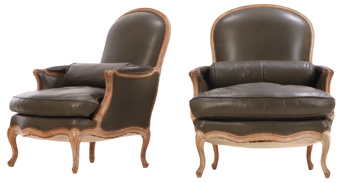 A PAIR OF LARGE FRENCH LOUIS XV STYLE NINETEENTH CENTURY BEECHWOOD LEATHER CLUB CHAIRS HAVING: A pair of Nineteenth century French Louis XV style carved Beechwood leather upholstered club chairs with pegged construction. having optional bolster cushions. Ht: 39.5" Wd: 34.5" Dpth: 34.5" Seat: 19