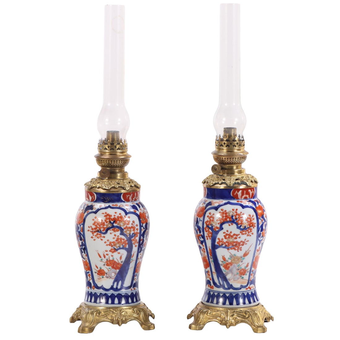 A PAIR OF IMARI VASES CONVERTED TO OIL LAMPS WITH BRONZE MOUNTS AND GLASS CHIMNEY, 19TH CENTURY.: A pair of Imari vases converted to oil lamps with bronze mounts and glass chimney, 19th century. Ht: 23.25" Wd: 6.5" Dpth: 6.5"