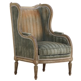 A PAINTED AND CARVED FRENCH LOUIS XVI STYLE UPHOLSTERED BERGERE CHAIR CIRCA 1900.