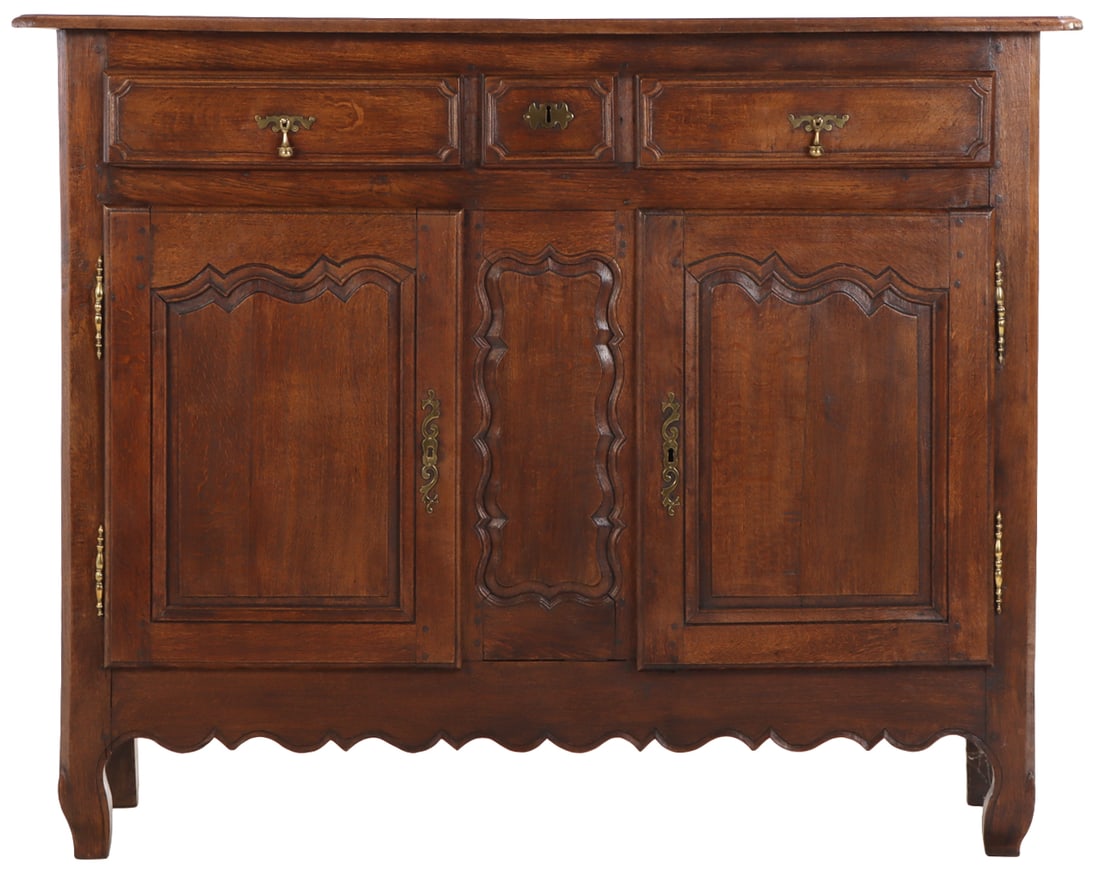 A LARGE EARLY 19TH CENTURY FRENCH WALNUT BUFFET HAVING THREE DRAWERS OVER TWO RECESSED PANELED: A large early 19th century French walnut buffet having three drawers over two recessed paneled doors and a scalloped skirt. Ht: 52" Wd: 65" Dpth: 24"