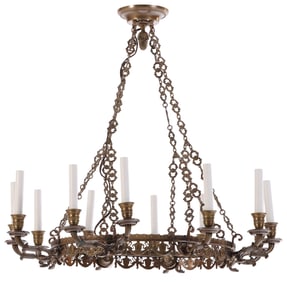 A FRENCH BRASS TWELVE ARM CHANDELIER HAVING RIBBON AND SWAG MOTIFS.