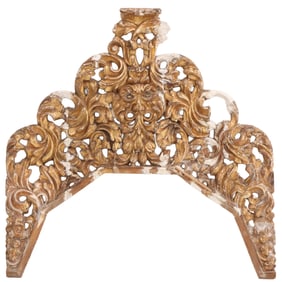 A CARVED AND GILTWOOD ARCHED CREST C 1920.