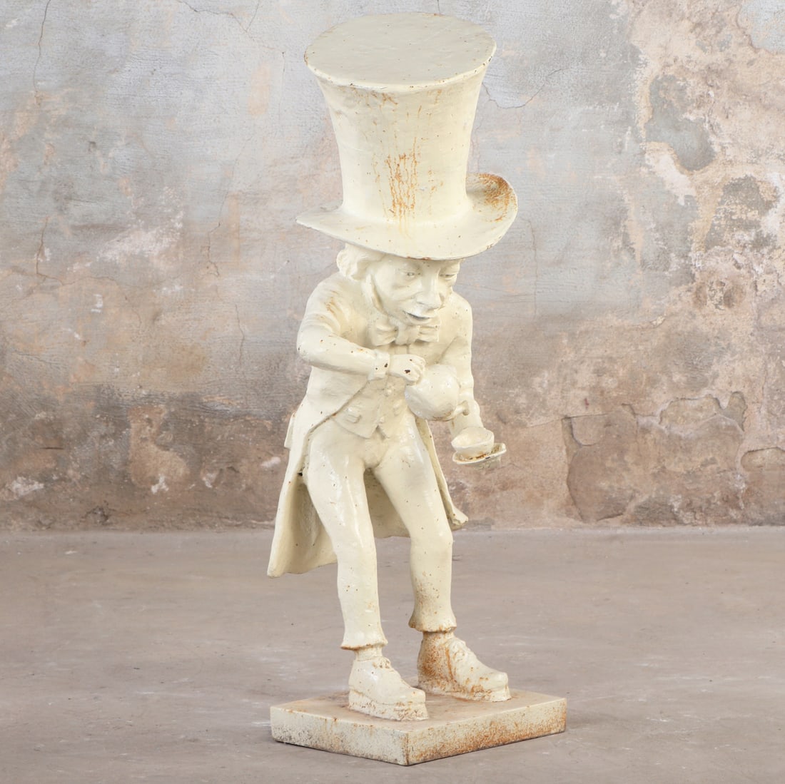 A PAINTED CAST IRON GARDEN SCULPTURE DEPICTING THE MAD HATTER POURING A CUP OF TEA. (1 of 5)