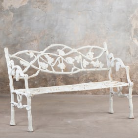 A PAINTED CAST IRON GARDEN BENCH HAVING OPENWORK BACK WITH TWIG AND LEAF MOTIFS.
