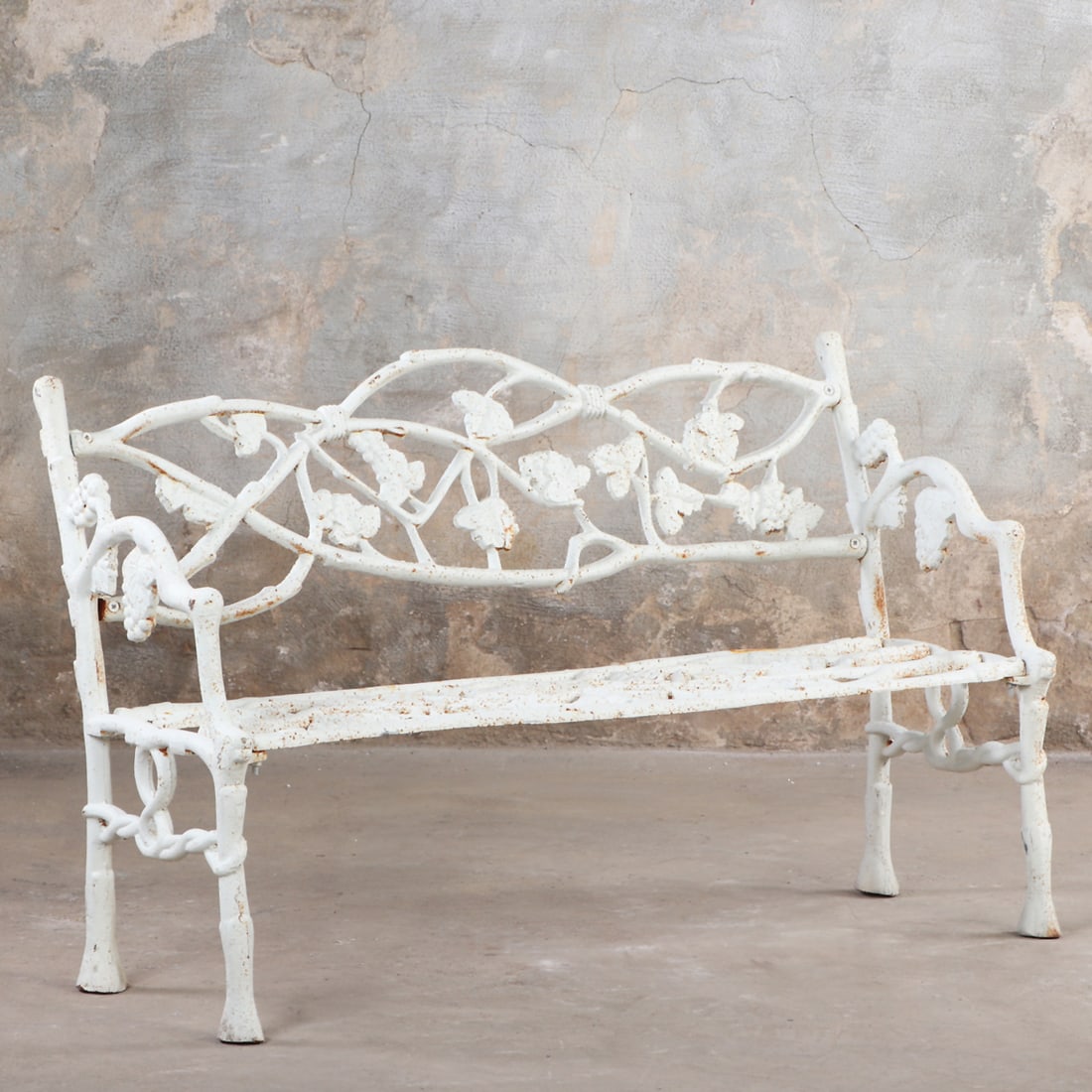 A PAINTED CAST IRON GARDEN BENCH HAVING OPENWORK BACK WITH TWIG AND LEAF MOTIFS.: A painted cast iron garden bench having openwork back with twig and leaf motifs. Ht: 31" Wd: 50" Dpth: 21" Seat: 14.75"