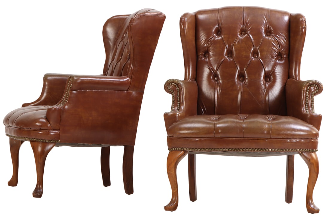 A PAIR OF BUTTONED LEATHER WING CHAIRS HAVING BRASS STUD DECORATION. (1 of 6)