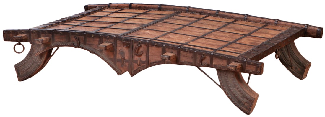 AN ANTIQUE HARDWOOD CAMEL CART TABLE HAVING IRON DECORATION.: An antique hardwood Camel cart table having iron decoration. Ht: 16.5" Wd: 73.75" Dpth: 51.25"