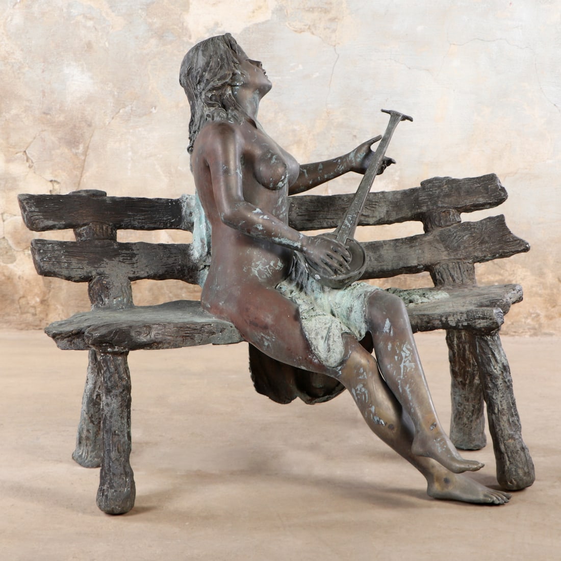 LIFESIZE BRONZE SCULPTURE OF A NUDE FEMALE PLAYING AN INSTRUMENT SITTING ON A BENCH. (1 of 7)
