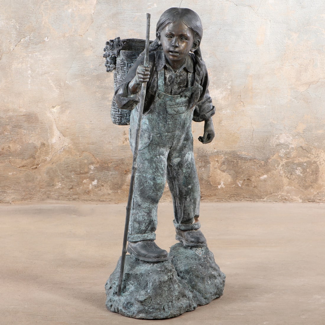 41" BRONZE GARDEN FIGURE DEPICTING A YOUNG WOMAN WITH A BASKET ON HER BACK.: 41" bronze garden figure depicting a young woman with a basket on her back. Ht: 41" Wd: 23" Dpth: 19.5"