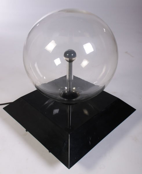 ELECTRIFIED GLASS KINETIC SCULPTURE BLACK BASE: An electrified glass kinetic sculpture atop angular black base. Ht: 16" Width: 14" Depth: 14"