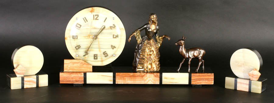 ANTIQUE ART DECO CLOCK GARNITURE SET CIRCA 1920: A beautiful Art Deco clock garniture set featuring a noblewoman petting a young doe circa 1920. Ht: 11" Width: 21" Depth: 4"