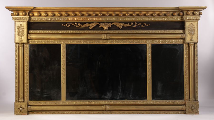 EMPIRE GILTWOOD GESSO CARVED MIRROR: An Empire giltwood and gesso carved mirror having a classical cornice above central cartouche and scroll work circa 1840. The three panels of mirrors flanked by columns. Ht: 47.5" Width: 88"