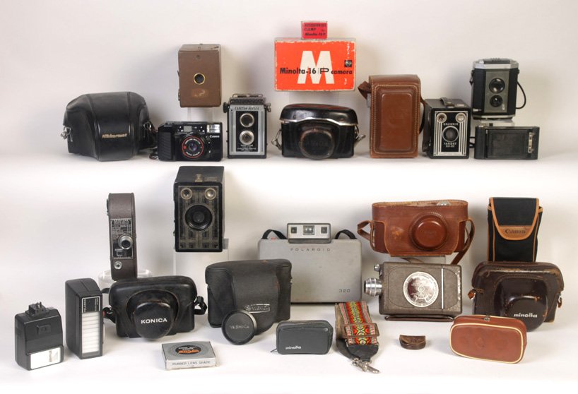 17 CAMERAS VARYING MANUFACTURERS CASES LIGHTING: A lot of seventeen cameras of varying manufacturers and styles, some with cases, accompanied by a variety of lighting devices.