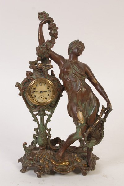 BRONZE WATERBURY NOUVEAU FEMALE TABLE CLOCK 1890: A bronze Waterbury Art Nouveau table clock featuring classically inspired female figure with lyre and spray of flowers, circa 1890. The works of the clock were recently cleaned and repaired. Ht: 14" W