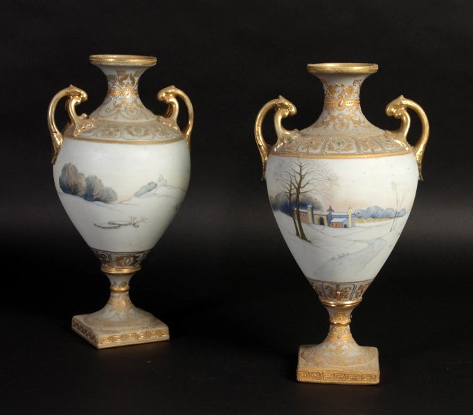 PR HANDPAINTED NIPPON VASES OUTDOOR SCENES: A pair of hand painted Nippon vases, urn shaped with double handles, having painted outdoor scenes circa 1940. Ht: 13" Width: 7" Depth: 6"