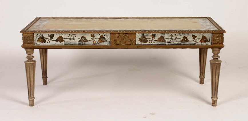 JANSEN EGLOMISE DECORATED COFFEE TABLE C.1940: Jansen eglomise decorated coffee table with silver and gold gilt decorated top and mirrored apron atop tapered and fluted legs circa 1940. Ht: 16.5" Width: 42" Depth: 21"