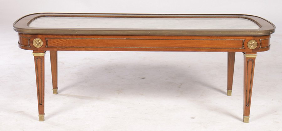 JANSEN DIRECTOIRE STYLE MAHOGANY COFFEE TABLE: A Jansen Directoire style mahogany coffee table, the top having a white inset marble framed in bronze circa 1940. Resting on a bronze mounted base with Elegant bronze capitals. Dimensions: Ht: 16" Wid