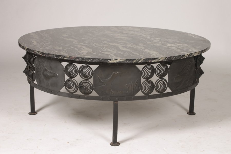 20TH C.ART DECO STYLE WROUGHTIRON COFFEE TABLE: A twentieth Century Art Deco style wrought iron coffee table having stone top over an apron with eight different animal bas relief plaques. Ht: 20" Dia: 48"