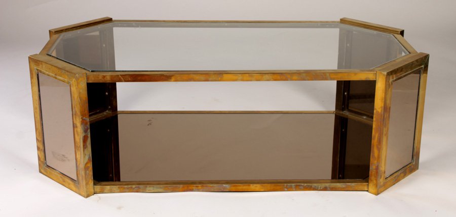 MODERN BRASS COFFEE TABLE MIRRORED SHELF: A mid century modern brass coffee table having inset octagonal glass top over lower mirrored shelf circa 1960. Ht: 16" Width: 49" Depth: 25.5"