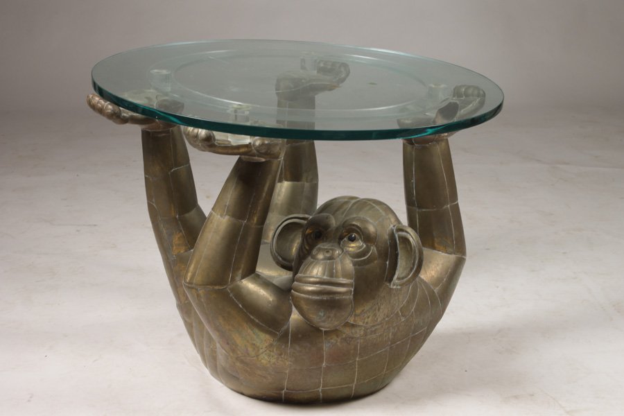 SERGIO BUSTAMANTE MONKEY FORM SIDE TABLE C.1970: A Sergio Bustamante monkey form side table having glass top supported by lucite ring and reclining monkey, circa 1970. Ht: 23" Dia: 32"