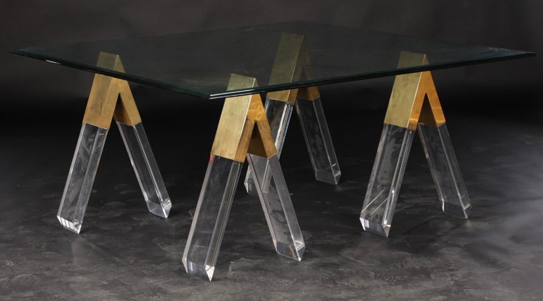 PIERRE CARDIN STYLE DINING TABLE LUCITE LEGS: A very interesting Pierre Cardin style lucite and bronze dining table having four lucite saw horse legs with bronze connecters, circa 1970. With beveled glass top. Ht: 29.75" Width: 63.5" Depth: 63.5"