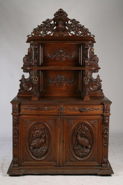 OAK VICTORIAN SIDEBOARD GRIFFINS DOGS FOWL CIRCA 1880: A great oak winged griffin black forest sideboard circa 1880. The top crest having a carving of a wild boar flanked by dogs over two shelves supported by winged griffins. The case having two drawers a