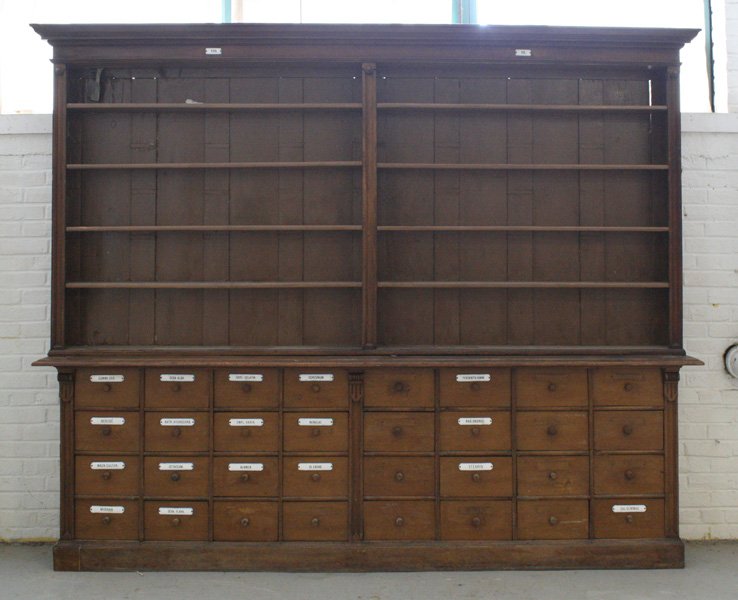 LARGE 2-PIECE APOTHECARY CABINET CIRCA 1900: Large two piece turn of the century apothecary cabinet having five double wide shelves atop thirty-two drawers circa 1900. All with enameled metal plaques. Ht: 90" Width: 113" Depth: 15"