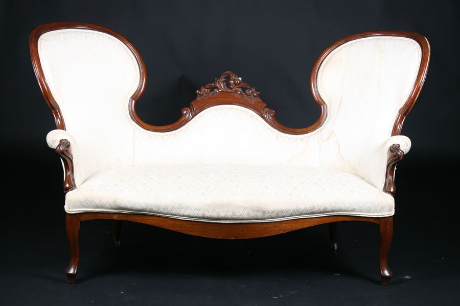 AMERICAN VICTORIAN CARVED MAHOGANY PARLOR COUCH: American Victorian carved mahogany parlor couch, circa 1880. Having central floral and scroll cartouche flanked by two arched chair backs with carved arms and shaped skirt. Ht: 40" Width: 68" Depth: 3