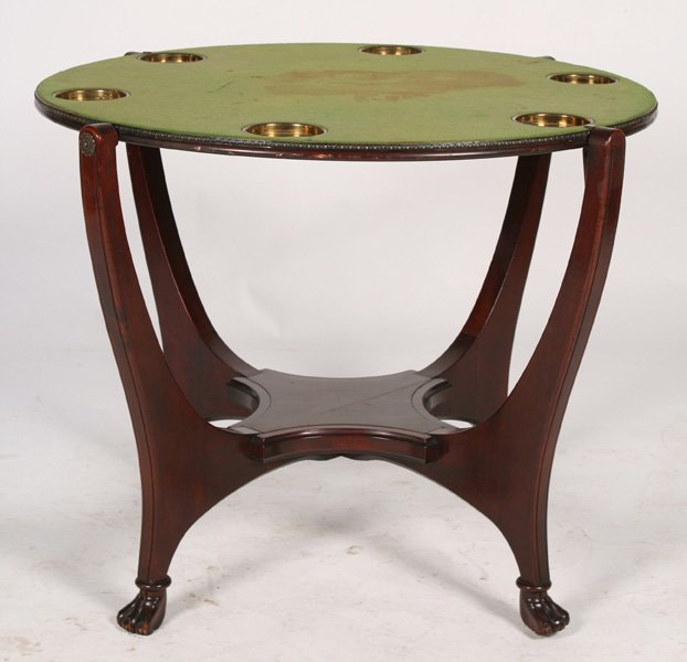 MAHOGANY HUNZINGER ROTATING TOP GAMES TABLE: Mahogany Hunzinger rotating top games table having felt top with drink cups supported on downswept legs with stylized paw feet circa 1900. Ht: 29.5" Dia: 39.5"