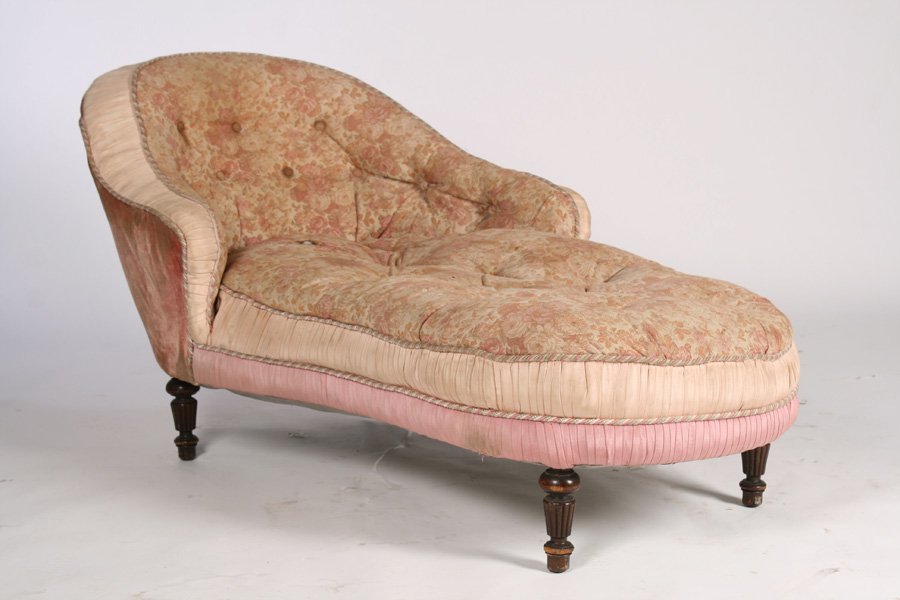 VICTORIAN UPHOLSTERED CHAISE LOUNGE 1880: A Victorian upholstered chaise lounge having tufted and shaped back and seat raised on turned and fluted legs circa 1880. Ht: 31" Width: 63" Depth: 35"