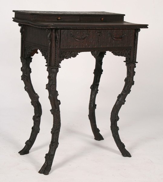 BLACK FOREST INSPIRED WRITING TABLE CIRCA 1890: A unique nineteenth Century Black Forest inspired writing table having stepped top with incised decoration over single drawer, circa 1890. Supported on faux Bois cabriole legs. Ht: 31" Width: 24" Dept