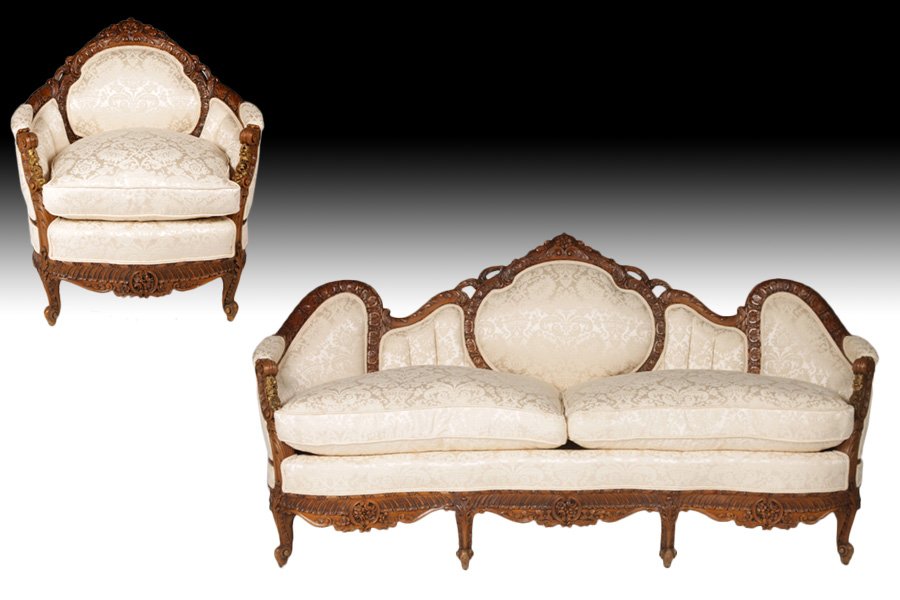 2 PC CARVED SALON SET SOFA BERGERE CIRCA 1920: A two piece salon set having elaborately carved sofa with shaped back and continuous arms together with a bergere. All with loose cushions.Circa 1920. Ht: 40.5" Width: 79" Depth: 26"
