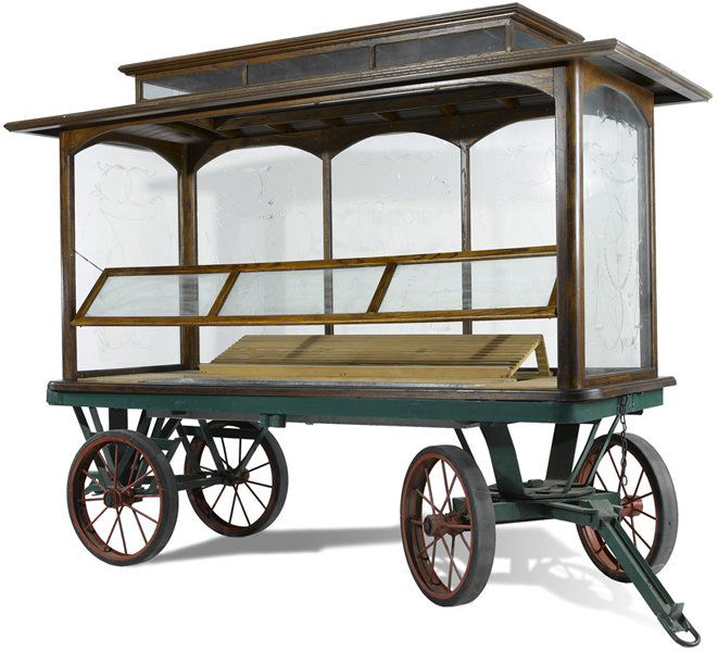 COMMERCIAL VINTAGE STYLE GLASS FRUIT CART: A commercial vintage style fruit cart having tiered arched top over engraved glass sides with scroll decoration. With slotted interior raised on iron frame with large spoke wheels. Ht: 102" Width: 134