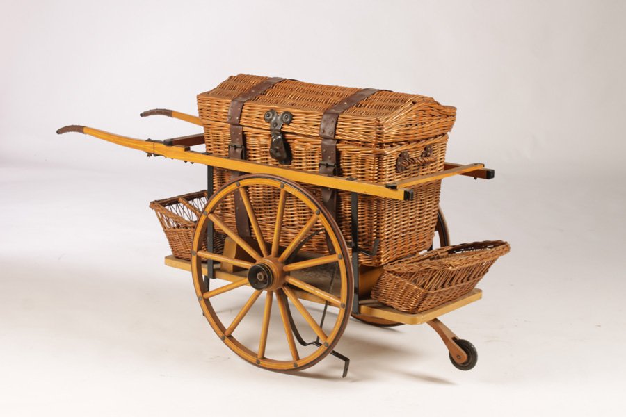 UNUSUAL WICKER PICNIC CART: Unusual wicker picnic cart having large fitted picnic basket mounted on wheeled cart. Ht: 27" Width: 50" Depth: 18"