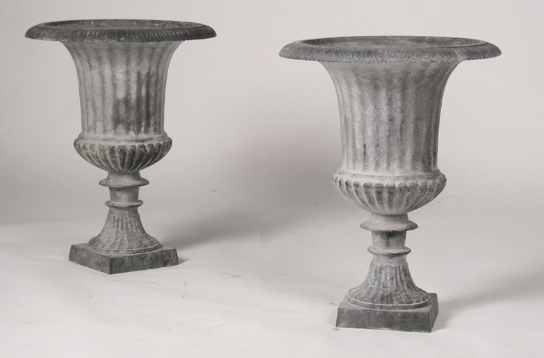 PAIR OF CAST IRON GARDEN URNS WITH LEAD WASH: A pair of cast iron garden urns having a lead wash finish and egg and dart rim. Ht: 24" Width: 19"