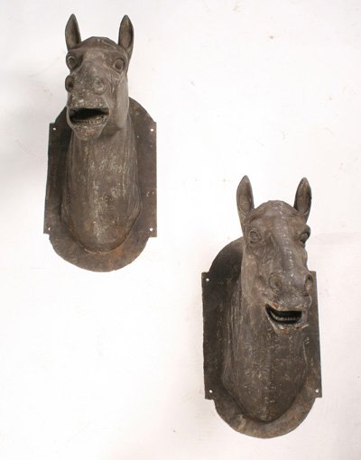 PAIR OF CAST IRON HORSE HEADS WITH BRONZE FINISH: A pair of cast iron horse heads with bronze finish mounted on back plates. Ht: 21" Width: 14" Depth: 25"