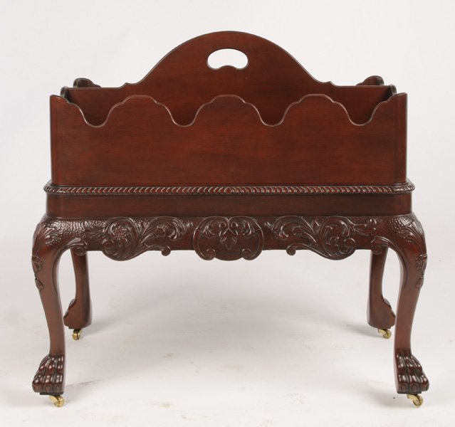 LABELED BAKER CARVED MAHOGANY MAGAZINE HOLDER: A labeled Baker carved mahogany magazine holder having removable scalloped edge tray seated on chippendale style base. Having cabriole legs with paw feet. Ht: 26.5" Width: 28" Depth: 16"